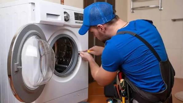 Technician inspecting the drum and door seal of a front-load washing machine